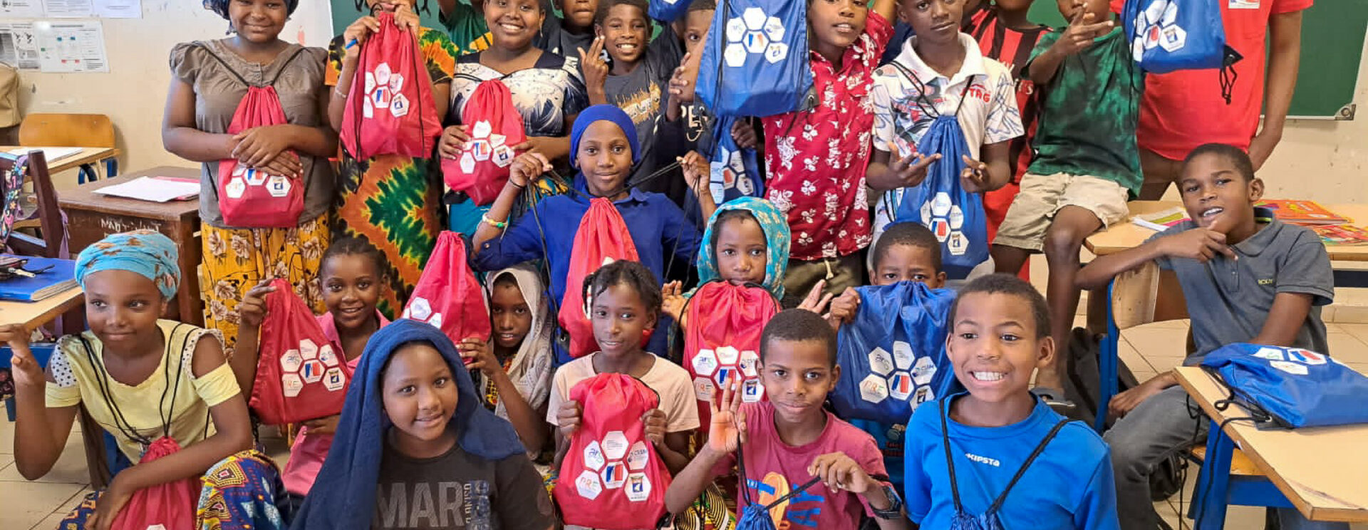 Groupes d'élèves dans une salle de classe tenant des sacs à dos