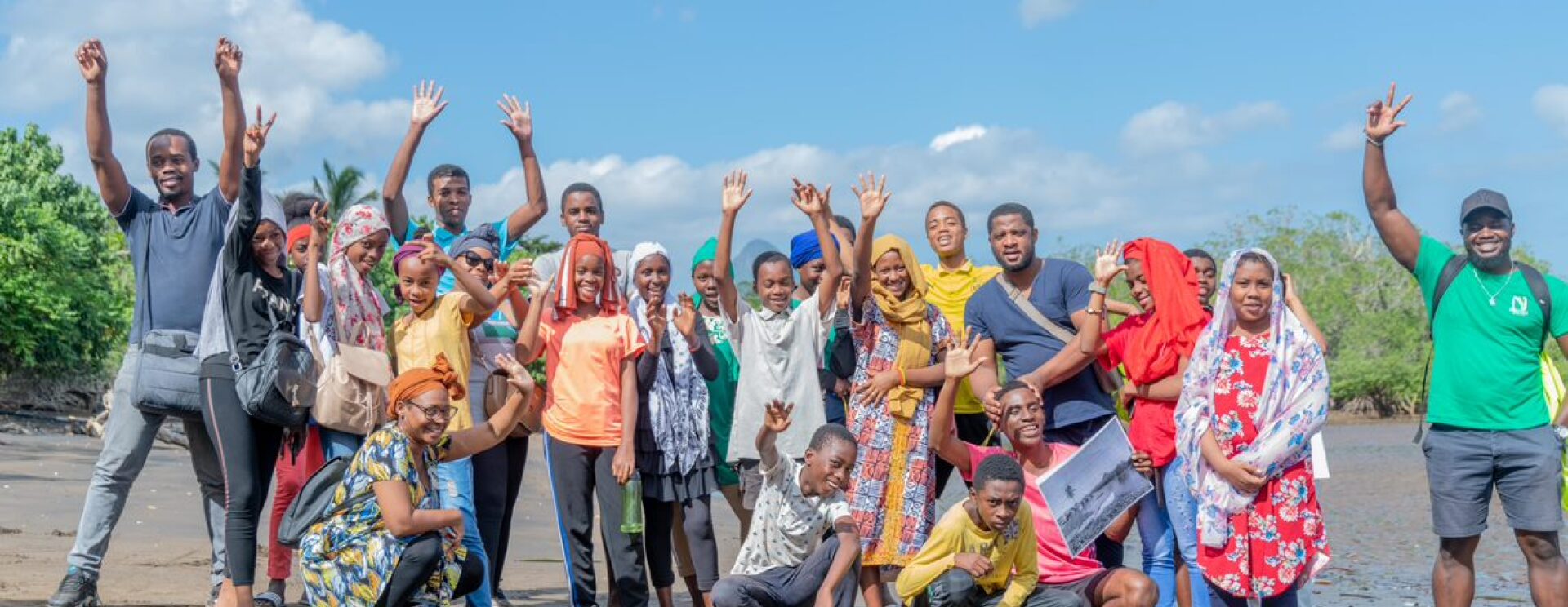 Groupes de jeunes enfants levant les bras sur une plage