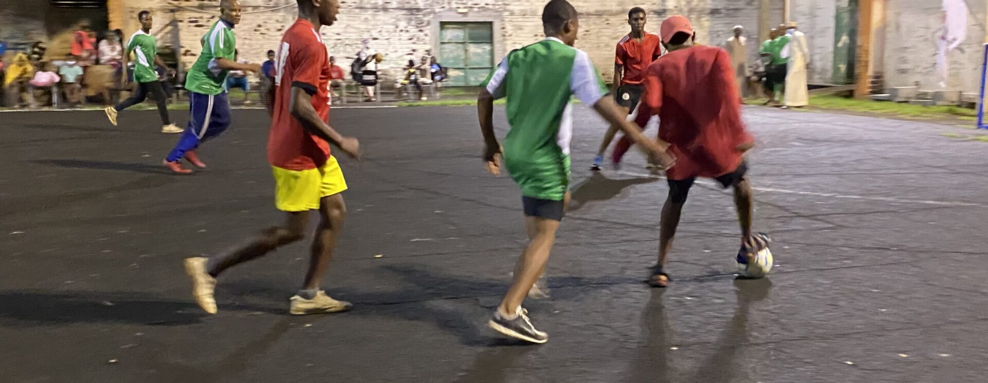 Equipe de jeunes garçons jouant au foot sur un plateau sportif