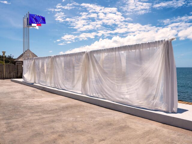 Drap blanc masquant les lettres urbaines géantes de Mamoudzou, sur le front de mer. - Agrandir l'image, fenêtre modale