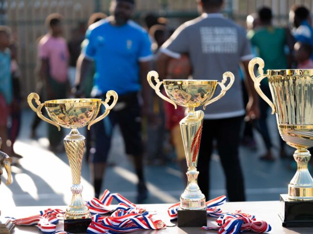Quatre trophées et des médailles sur une table lors d'un tournoi sportif - Agrandir l'image, fenêtre modale